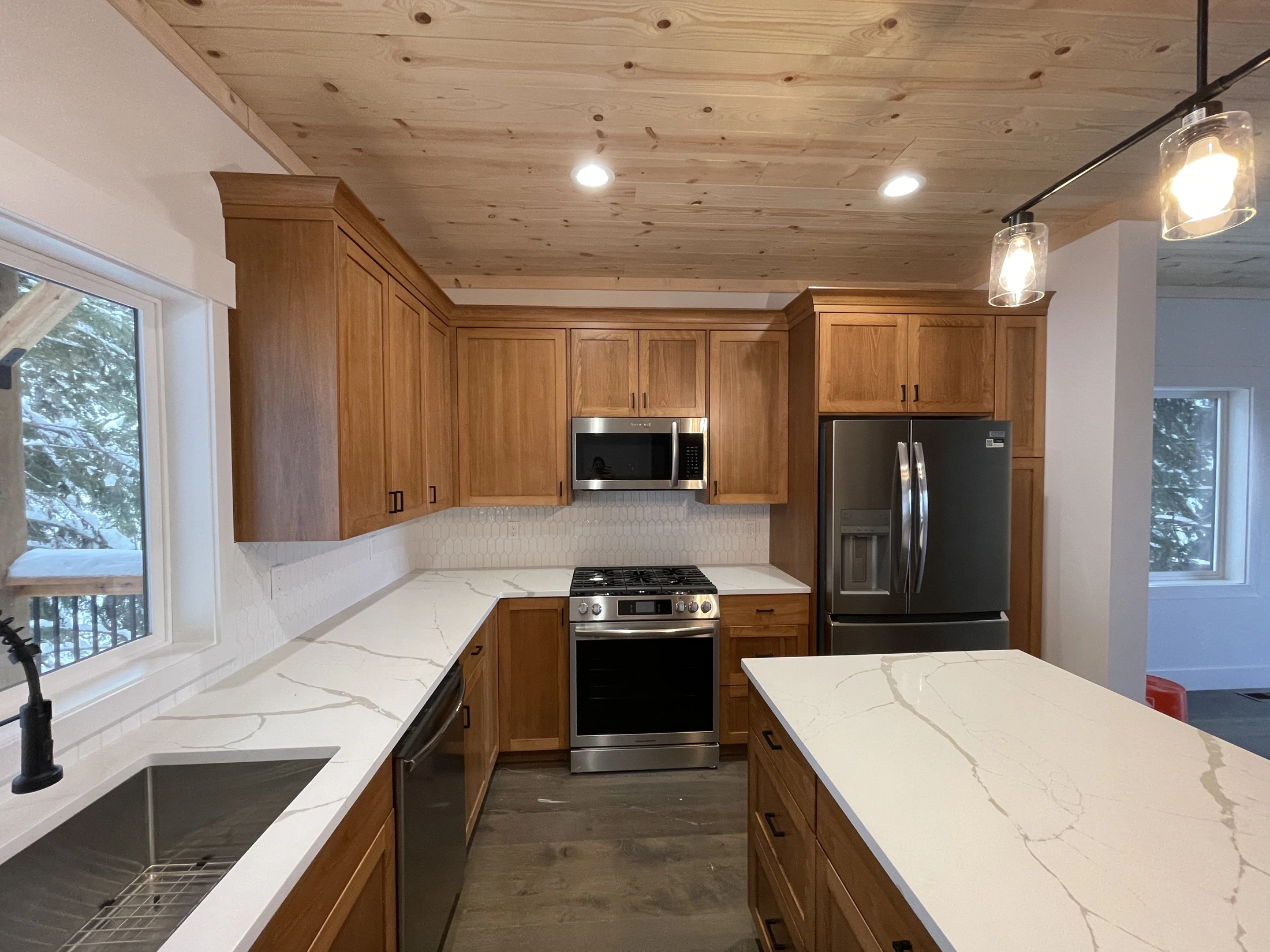 Completed oak kitchen with custom cabinetry, white counters, and a central island