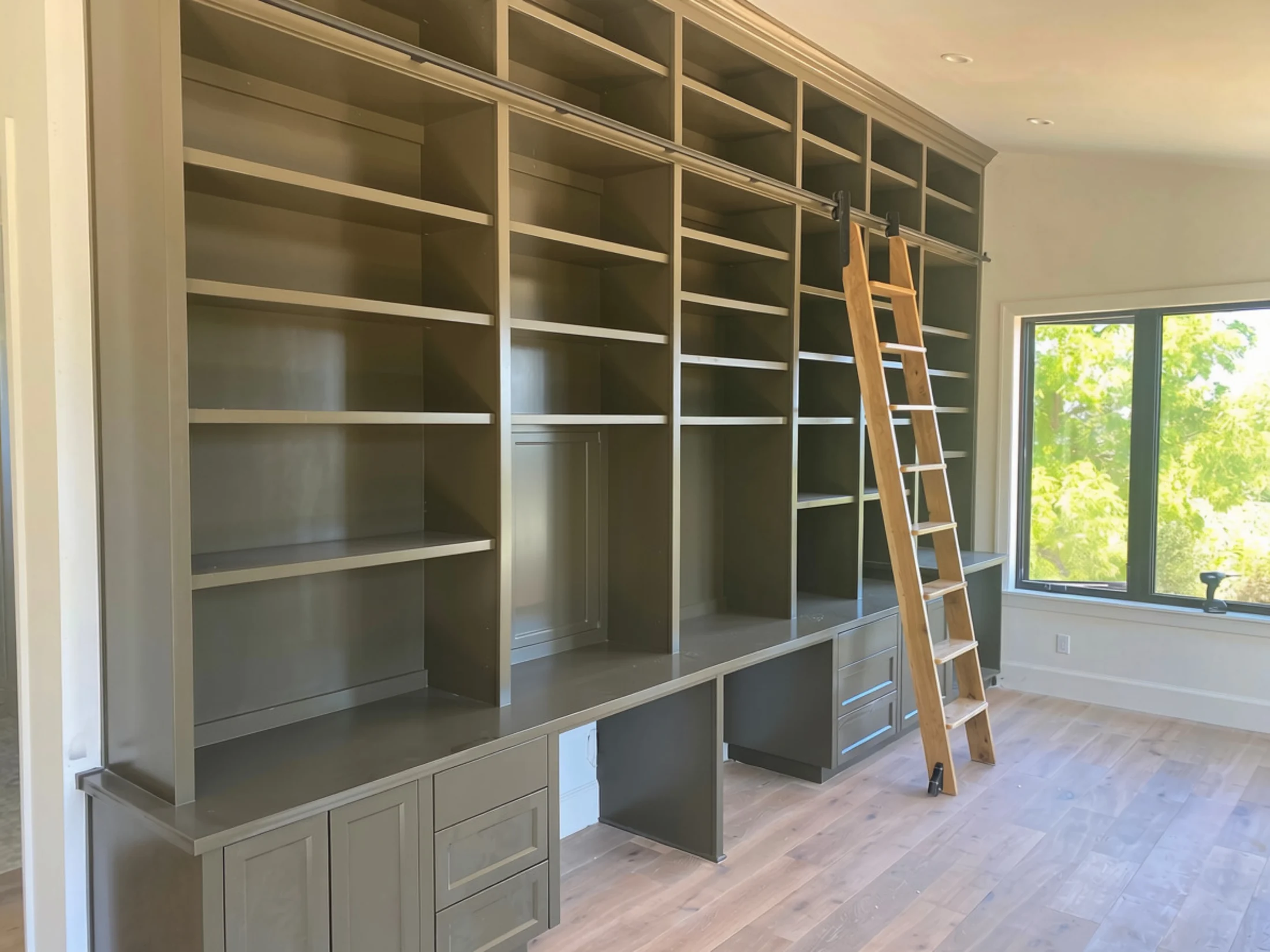 Floor-to-ceiling custom library built-in with rolling ladder and integrated desks