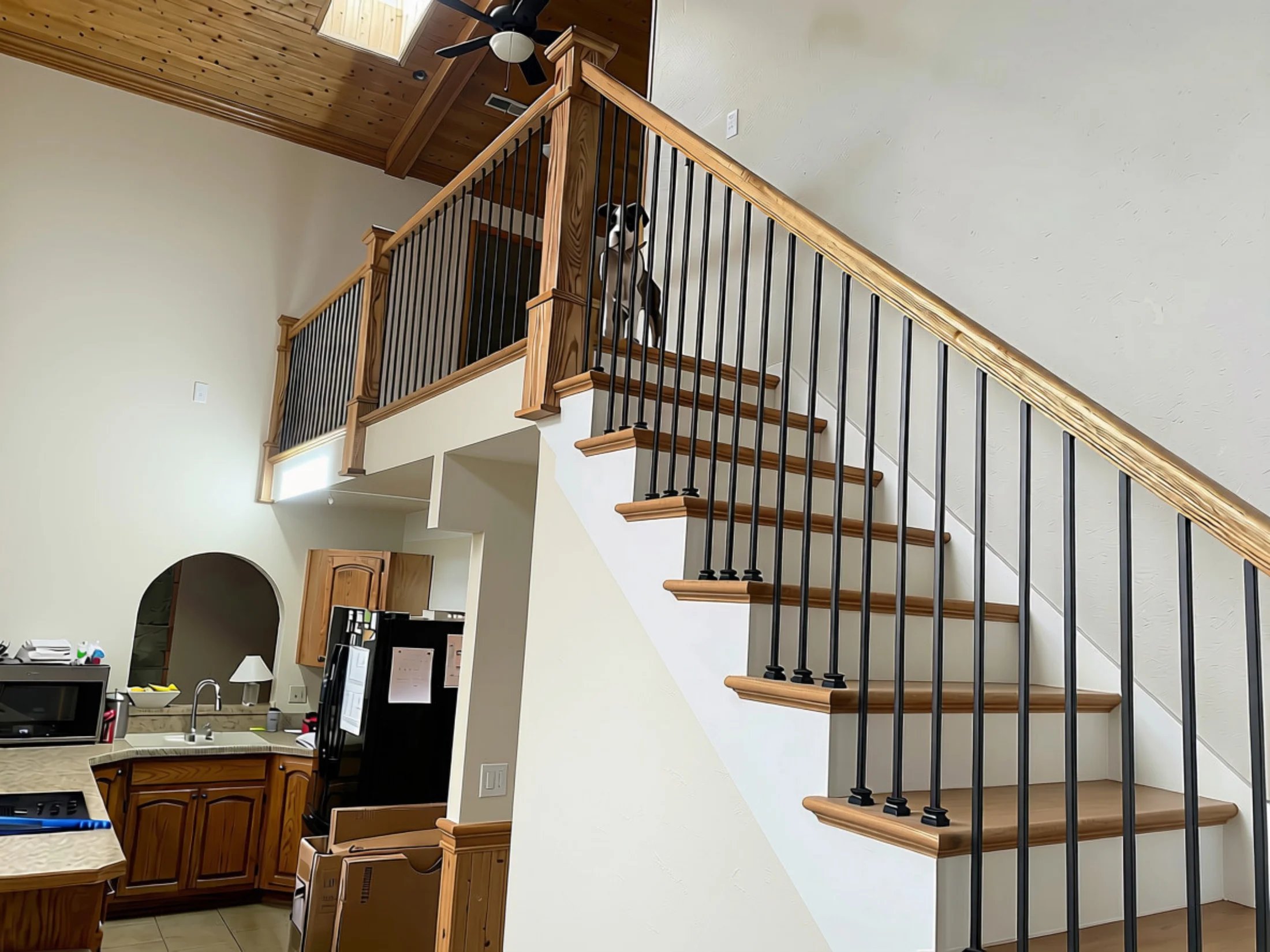 Completed white oak staircase with custom newel posts, handrail, and black iron balusters