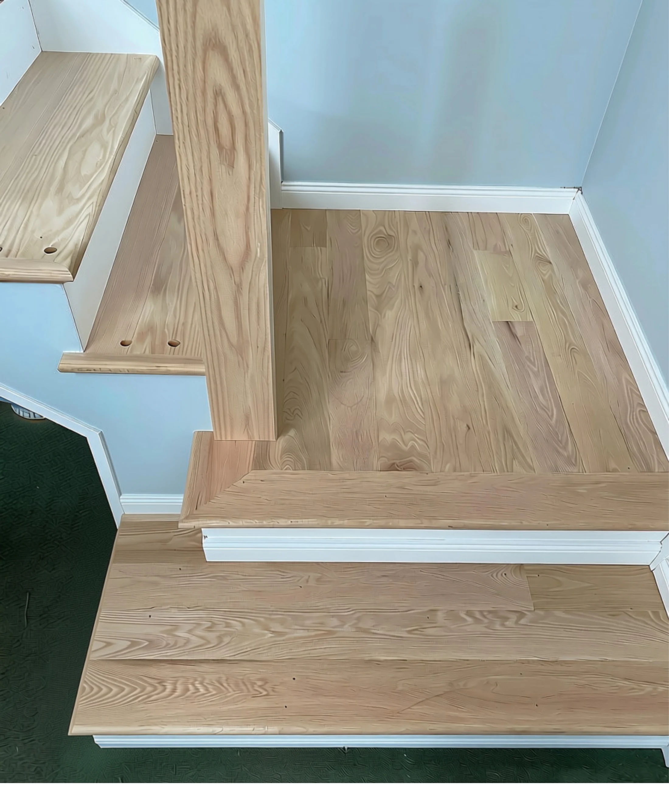 White oak stair landing with precisely fitted trim and transitions