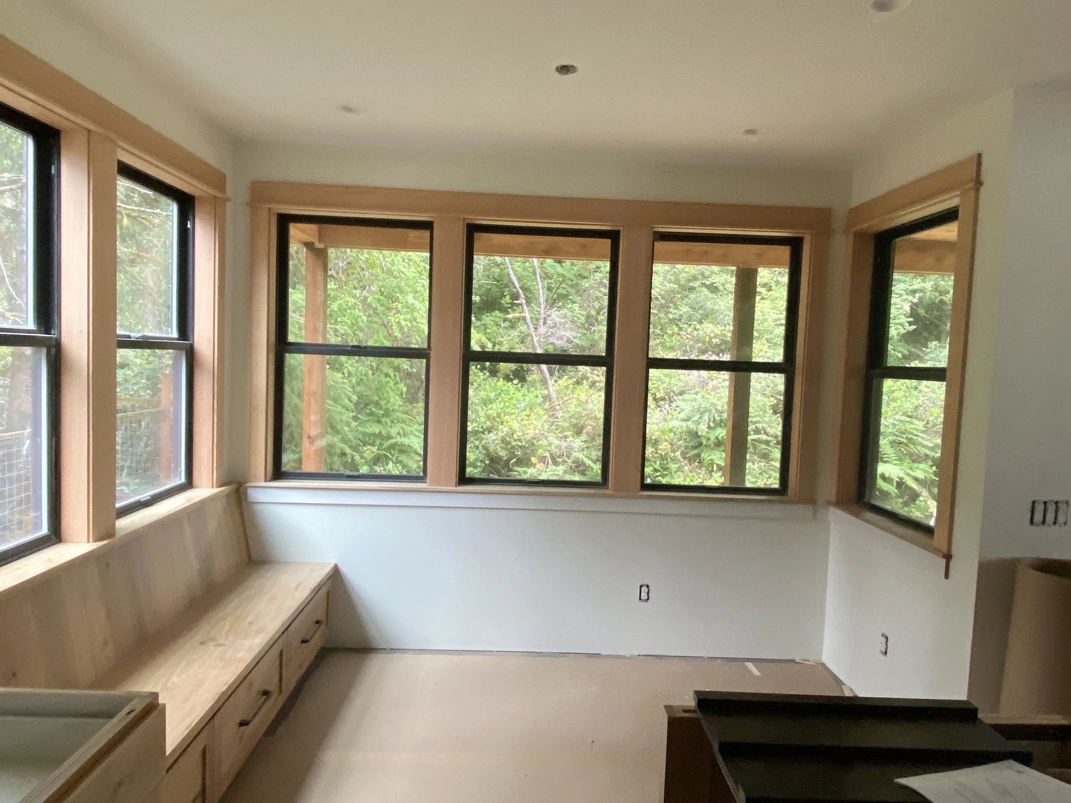Natural wood window trim fitted around a bright corner room